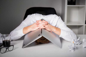 a man hides under his laptop and understands that There May Be Frustration with SEO